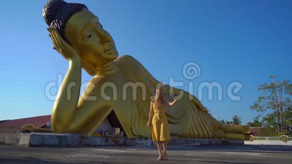 一位年轻的女旅行者带着一尊躺着的佛像参观了WatSrisoonthorn寺拍摄了一张慢镜头视频的预览图