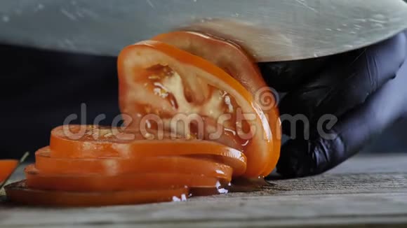汉堡沙拉或三明治的配料黑手套厨师将番茄切成圆环视频的预览图