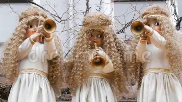 三个移动的天使娃娃他们穿着雪白的裙子在孩子们的圣诞市场的小亭的屋顶上视频的预览图