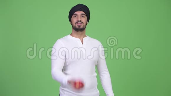 年轻快乐的留着红苹果的印度男人视频的预览图