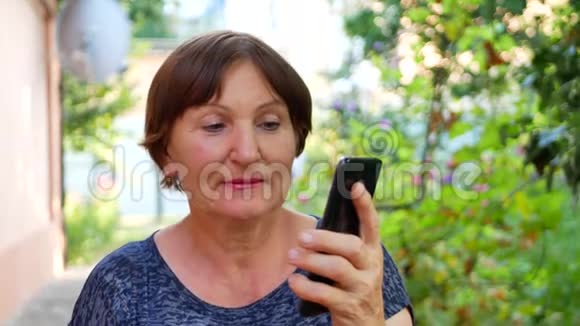 女人在家外的智能手机上表演视频的预览图
