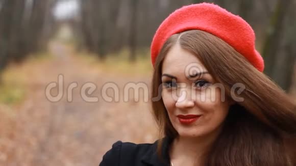 一位戴着红色贝雷帽和红唇的美女的肖像她微笑着看着室外的镜头视频的预览图