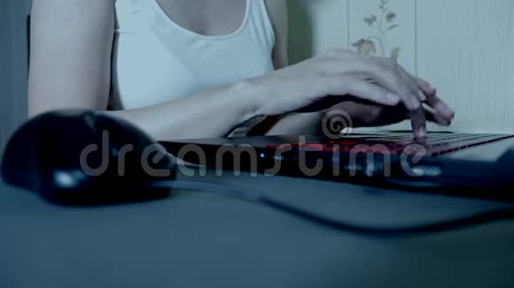 无法辨认的女人晚上在黑暗中用鼠标在笔记本电脑键盘上输入东西浅焦视频的预览图