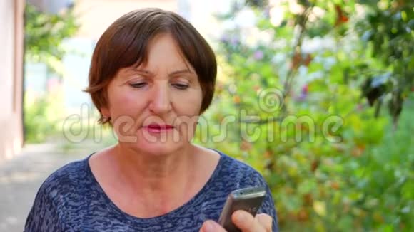 在外面使用手机的老年妇女视频的预览图