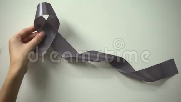 脑癌铭文女士把灰色丝带放在桌子上宣传活动视频的预览图