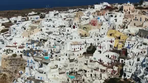 在圣托里尼岛上空飞行希腊有标志性的白色和蓝色建筑视频的预览图