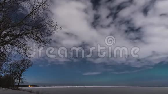 月光的云层和极光在冰冻的湖面上的时间流逝视频的预览图