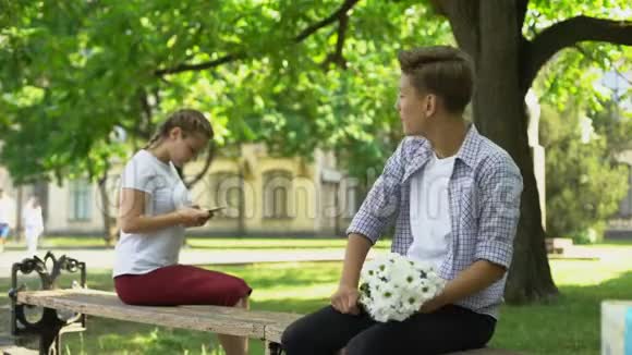 紧张的少年在公园给漂亮的女孩献花接主人视频的预览图