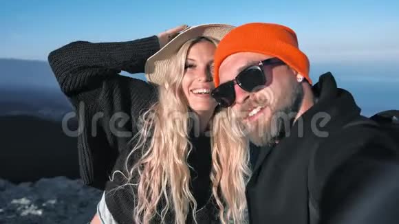 波夫拍摄旅行者夫妇的帽子摆着微笑送空气亲吻拉着脸自拍视频的预览图