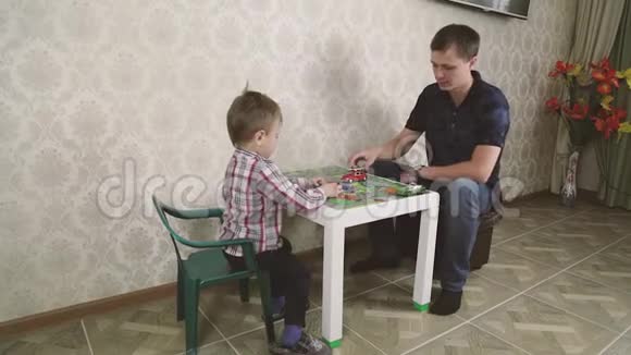 父亲和儿子在玩玩具车的同时也在微笑一起在家视频的预览图