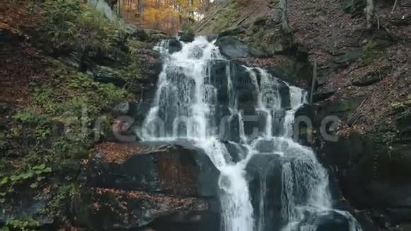 秋天瀑布从高山上落在石头上视频的预览图