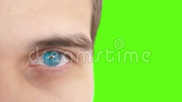 闭上一只雄性的眼睛一个人在绿色背景上看相机的蓝眼睛的细节3840x2160视频的预览图