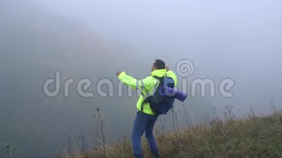 一个背着背包的游客爬上了山手里挥舞着快乐的尖叫慢悠悠地视频的预览图