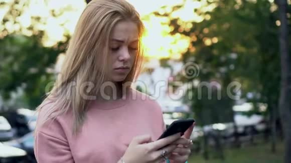 年轻女孩伤心地看着智能手机屏幕视频的预览图