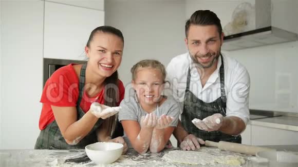 有趣的家庭在厨房里有乐趣他们用手吹面粉看上去很可爱视频的预览图