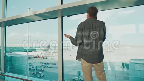 成年男子在机场候机楼用手机通话后景视频的预览图