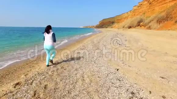 一个女人沿着海岸线跑镜头跟着她视频的预览图