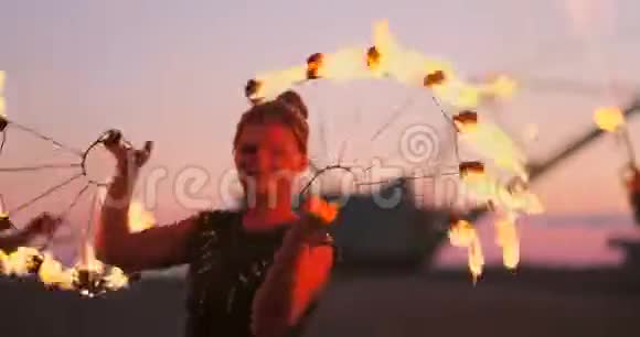 职业舞蹈家妇女在节日里用燃烧的闪闪发光的火把进行火秀和烟火表演视频的预览图