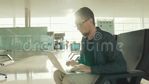 忙碌的成年商人正在机场候机楼的笔记本上打字视频的预览图