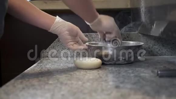 厨师将面粉洒在面团和烹饪台面上揉搓视频的预览图
