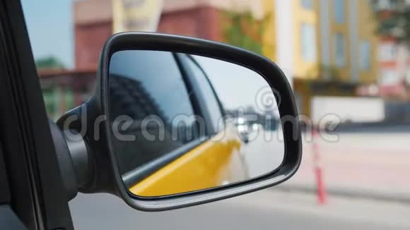 黄色出租车侧后视镜中城市交通流的反映视频的预览图