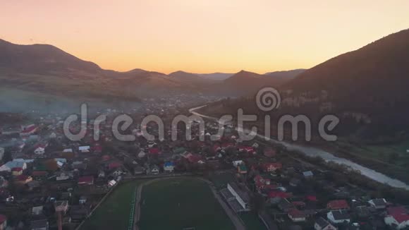 隐藏夕阳的山丘上的图案小镇建筑视频的预览图