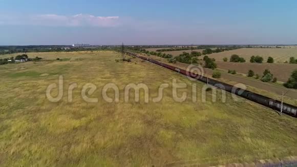 美丽的乡村景色田野和铁路有一列大型货运火车视频的预览图