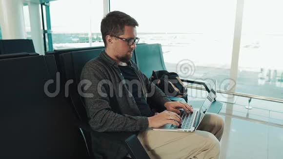 一个严肃的人在机场大厅里用免费无线上网视频的预览图