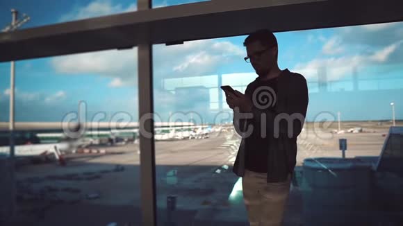 游客穿着休闲服装在机场与智能手机视频的预览图