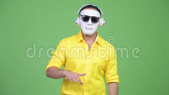 年轻的印度商人戴着白色面具做DJ视频的预览图