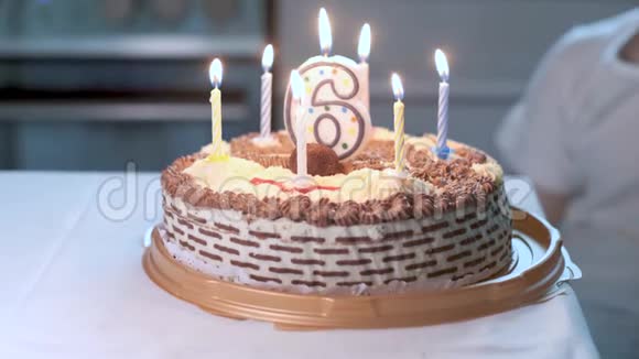在生日蛋糕上做特写上面有6号形状的点燃蜡烛视频的预览图