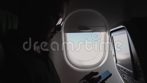 商务人士正在飞机机舱内使用智能手机视频的预览图
