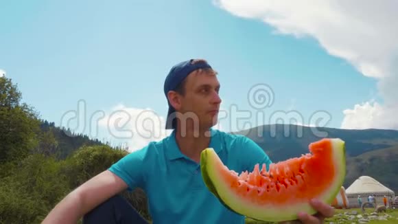 肖像帅哥在夏日户外吃新鲜西瓜视频的预览图