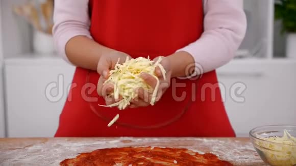 年轻女孩的手在披萨上撒些奶酪视频的预览图
