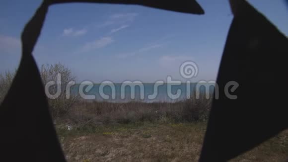 在湖的背景下拖车门口迎风摇曳的三角旗视频的预览图