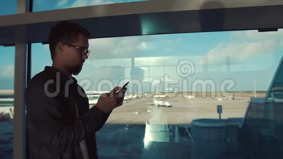 严肃的男人正在智能手机里看信息站在机场大厅里视频的预览图