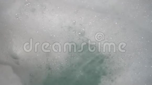 淋浴间的水流把一堆泡沫吹进浴缸泡沫形成和坠落视频的预览图