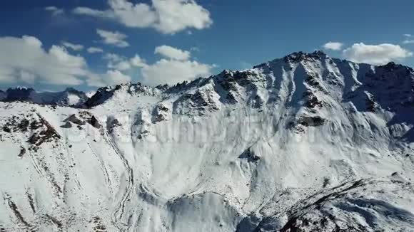 巨大的群山覆盖着雪山峰的全景蓝天白云视频的预览图