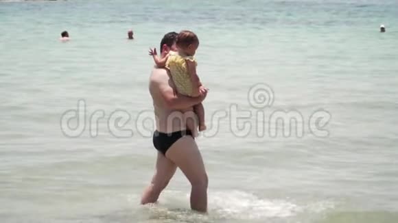 爸爸和小女孩穿着黄色的游泳衣在海里玩耍希腊雅典父亲视频的预览图