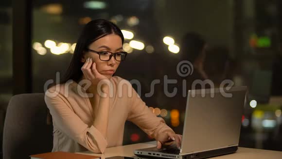 无聊的女人在笔记本电脑上工作加班加点缺乏动力视频的预览图