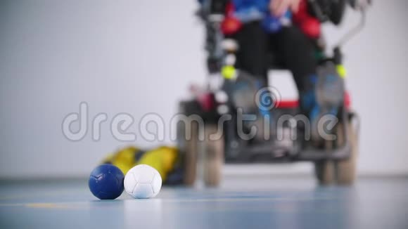 坐轮椅的残疾人框架中的白色蓝色和红色的球三色视频的预览图