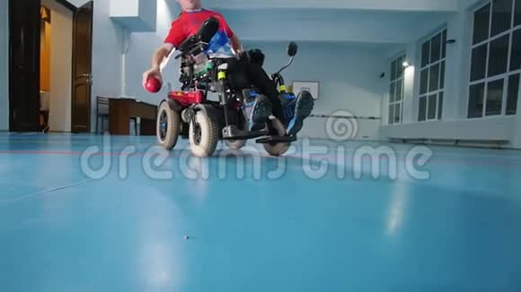 坐轮椅的残疾人扔红色的小球大体育馆慢动作视频的预览图