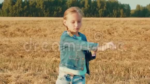 秋天的田野里美丽的少女在旋转时吹着肥皂泡视频的预览图