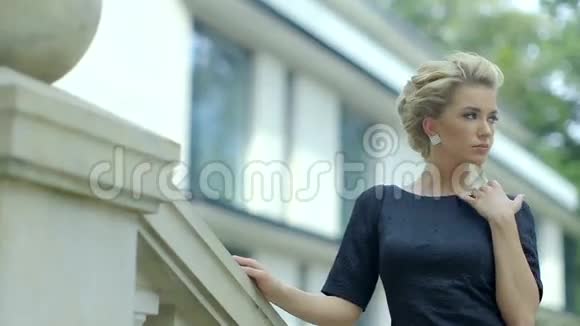 美丽优雅的白种人女人穿着黑色的裙子走上楼外视频的预览图