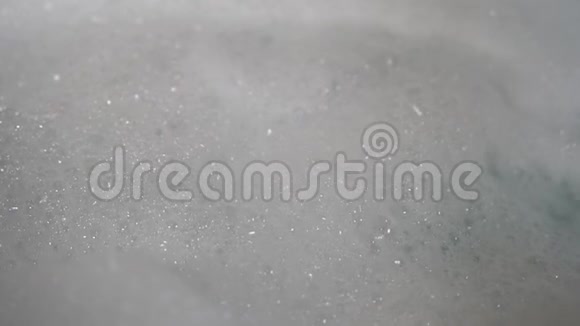淋浴间的水流把一堆泡沫吹进浴缸泡沫形成和坠落视频的预览图