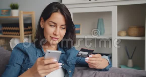 在网上付款的年轻女士拿着银行卡触摸智能手机屏幕视频的预览图