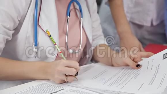 在办公室做文书工作的女医生年轻的治疗师坐在办公桌前填写医疗清单保健视频的预览图