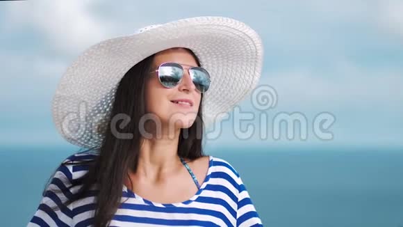 慢动作女人欣赏太阳眼镜和海景反射的美丽天空视频的预览图