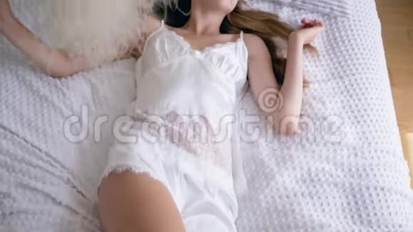 快乐女孩的肖像躺在睡衣的床上身上有一束羽毛草视频的预览图
