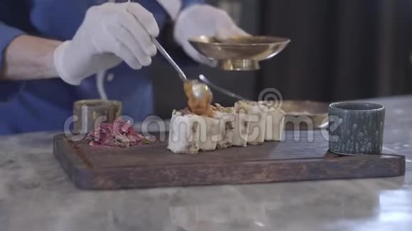 厨师在现代餐厅烹饪美味的菜肴穿着厨师制服和戴着橡胶手套的人的手视频的预览图